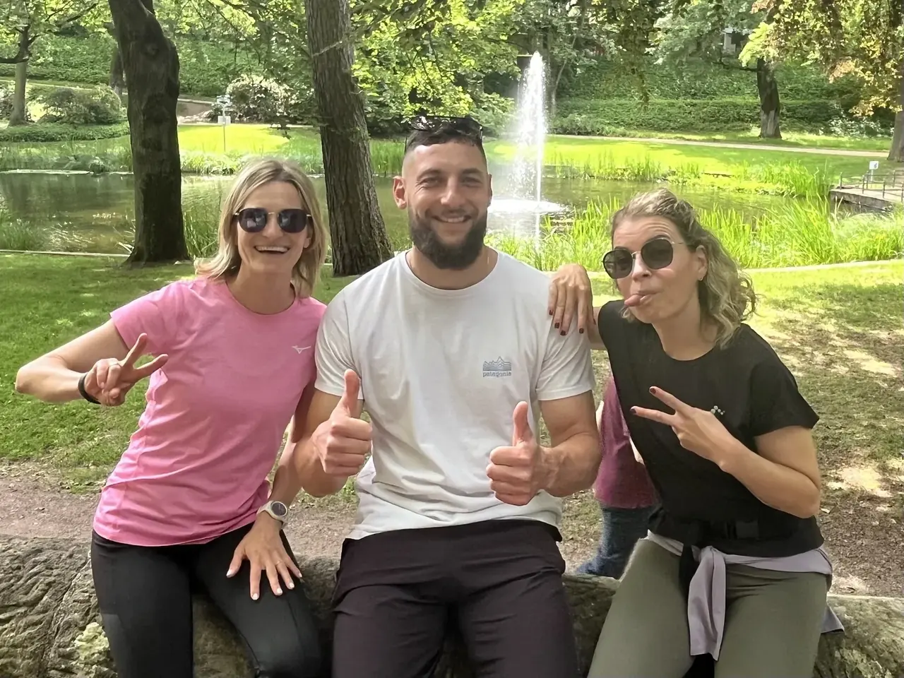 Trainer Wadim mit zwei gut gelaunten Teilnehmerinnen im Park