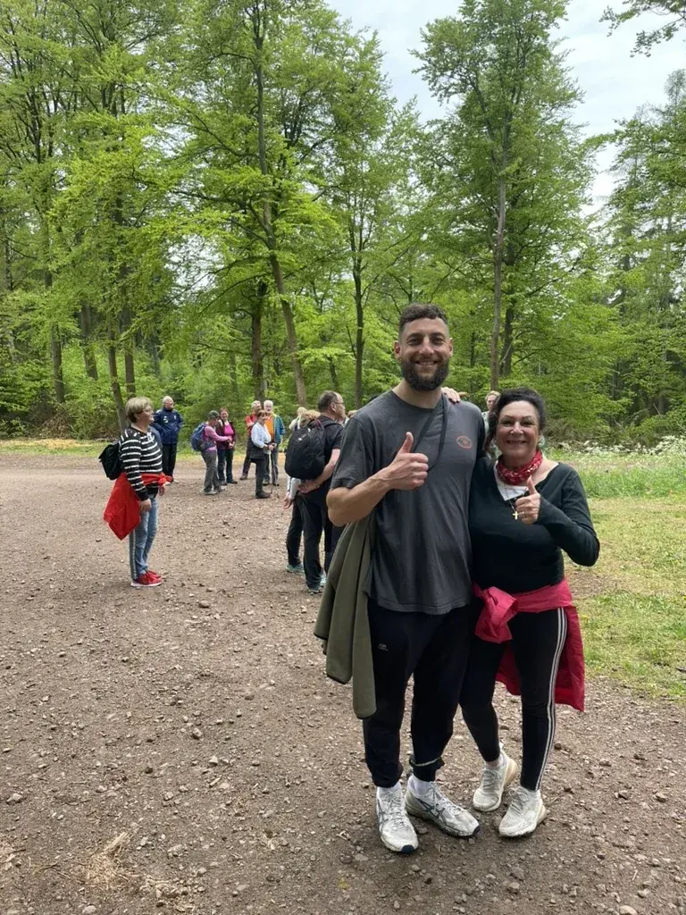 Trainer Wadim mit einer Teilnehmerin beim Wandern im Wald