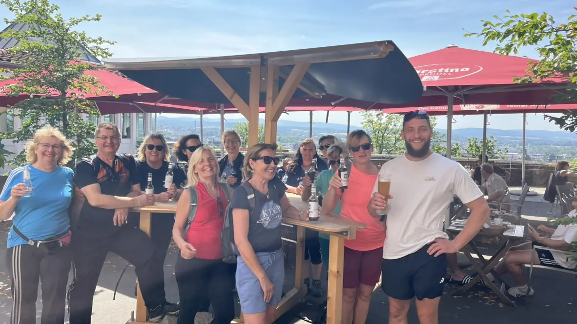 Gemeinsame Einkehr der Gruppe auf einer sonnigen Terrasse