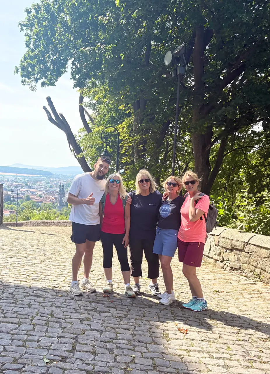 Gruppenfoto von fünf Teilnehmenden mit Blick über die Stadt im Sommer