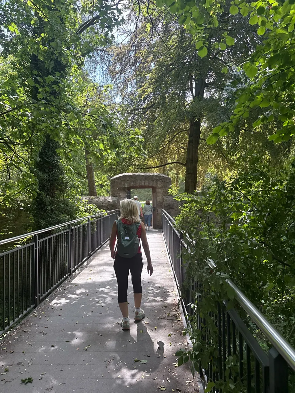 Teilnehmerin auf einer Parkbrücke, im Hintergrund ein altes Torhaus