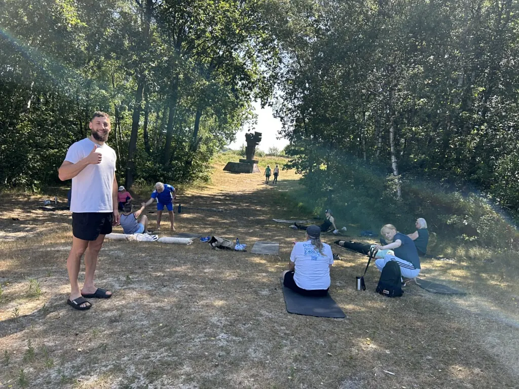 Trainer Wadim bei einer Bewegungseinheit im Freien mit der Gruppe auf Matten